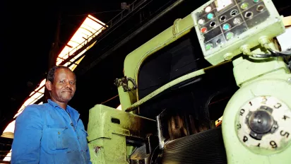 Worker at Addis Tyre Company stands next to a machine in an automobile tire production line Addis Ababa. Ethiopia