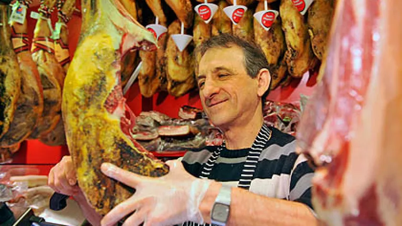 Butcher working at Boqueria market, located on the Ramblas in Barcelona