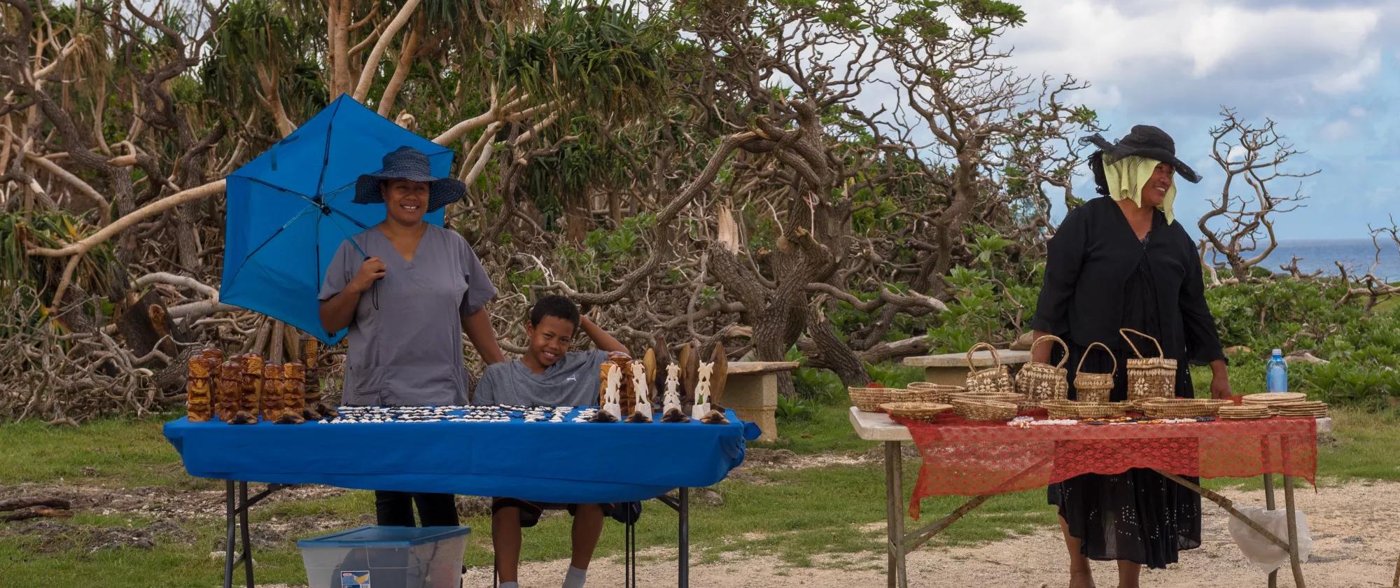 Merchants display baskets and local artwork for sale near the town of Houma in Tonga.