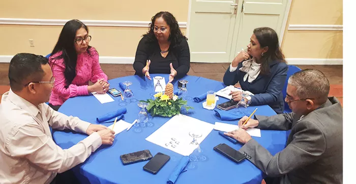 A group of people in discussion around a table at a training workshop