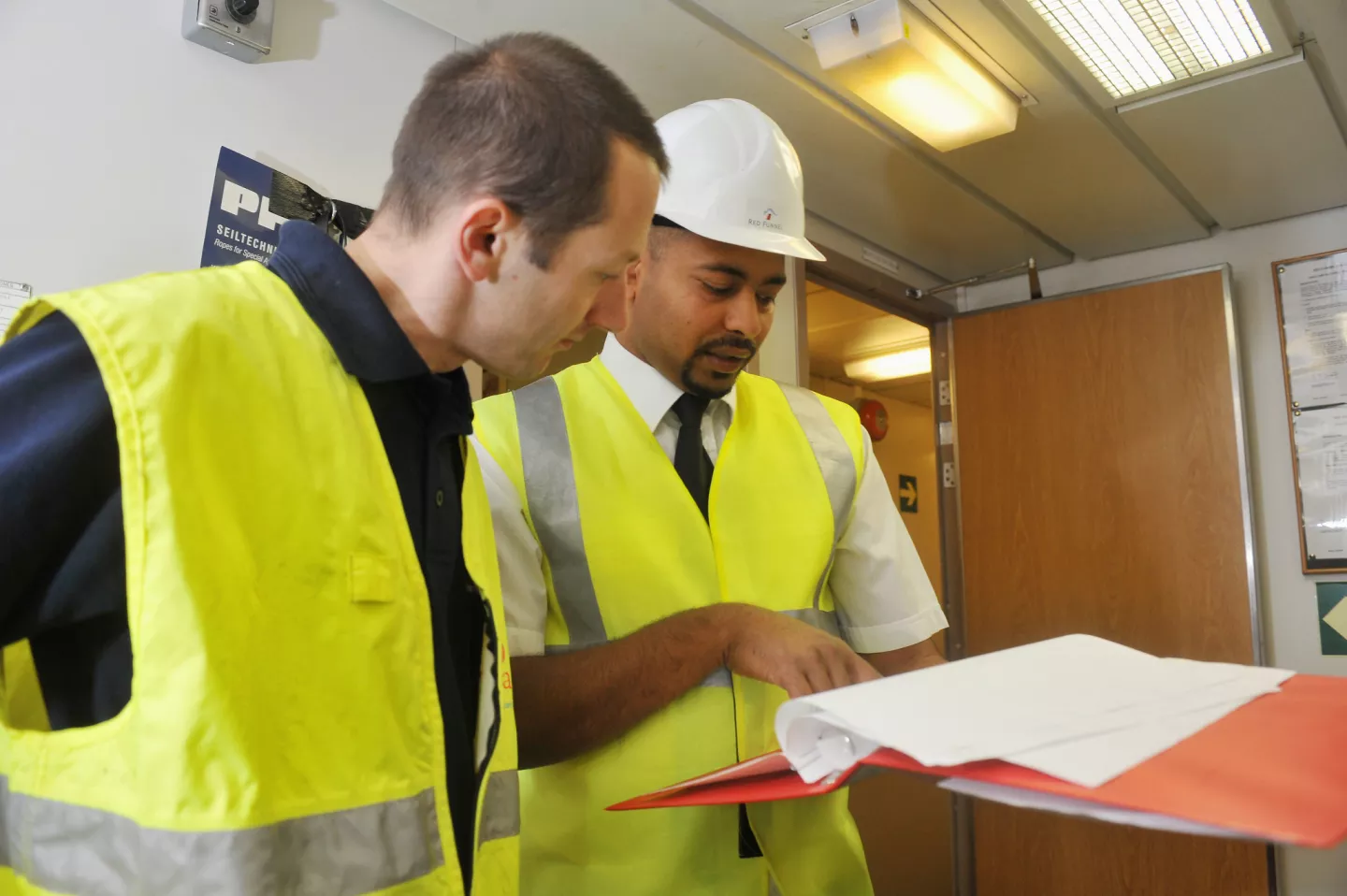 Officers and ship inspector checking the ship's compliance with safety standards