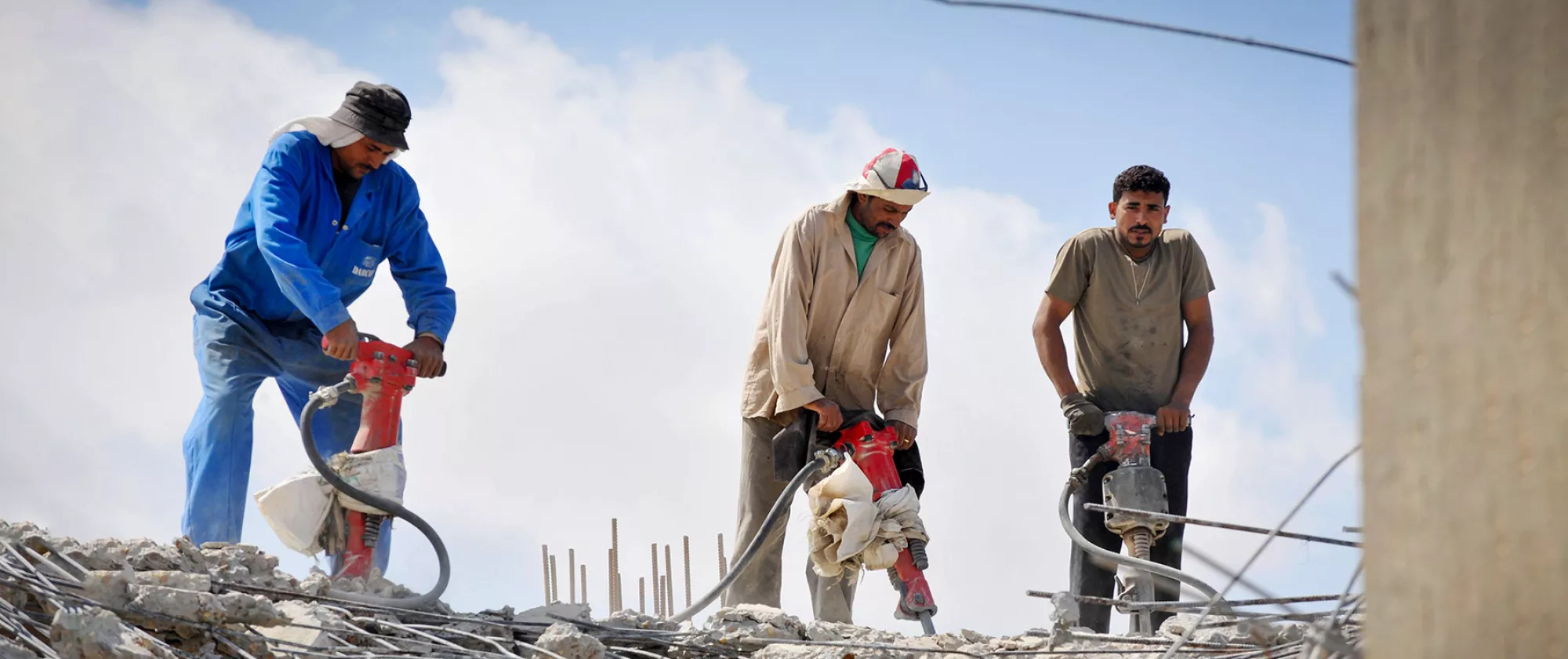 Construction workers breaking concrete in Libya