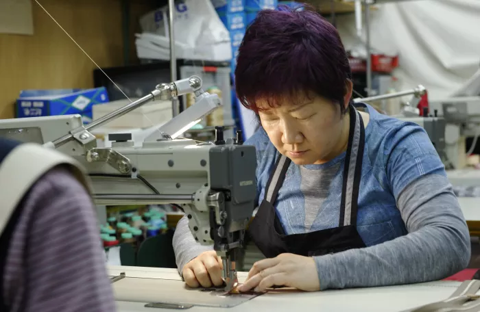 A woman focused on sewing with a sewing machine.