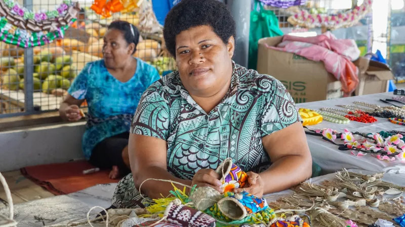 Fijian women making and selling crafts for tourists in Farmers and craft market in Fiji.