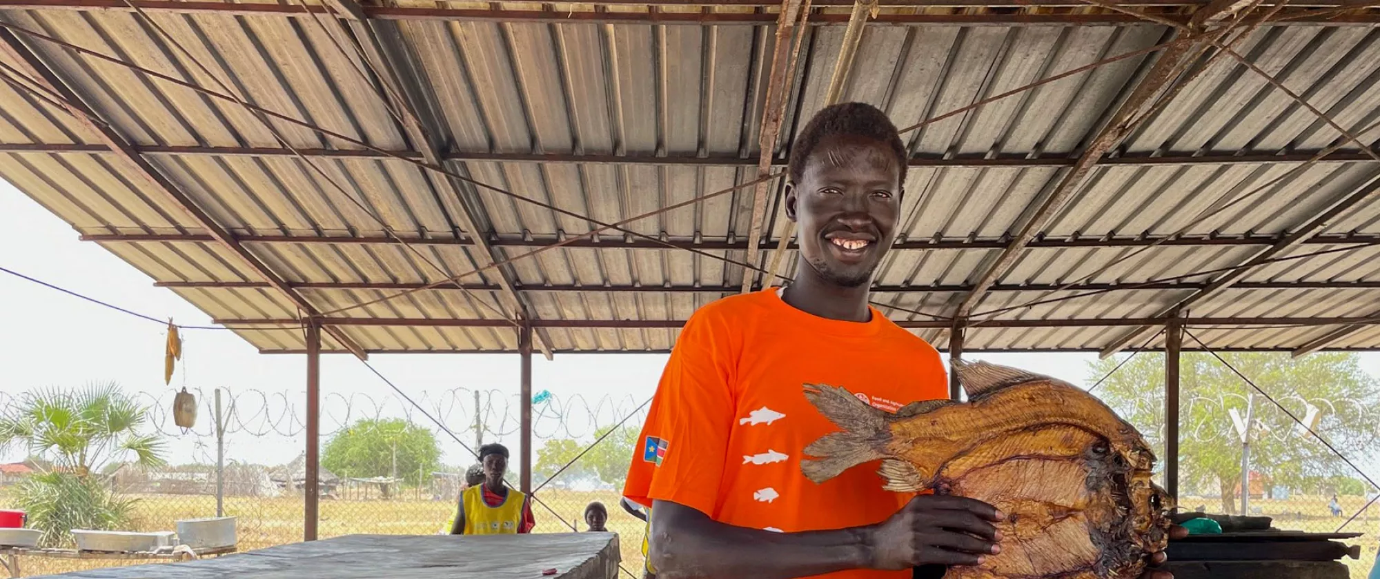 Alphonso Lado Modi, a beneficiary of a FAO project in South Sudan holds up a dried fish