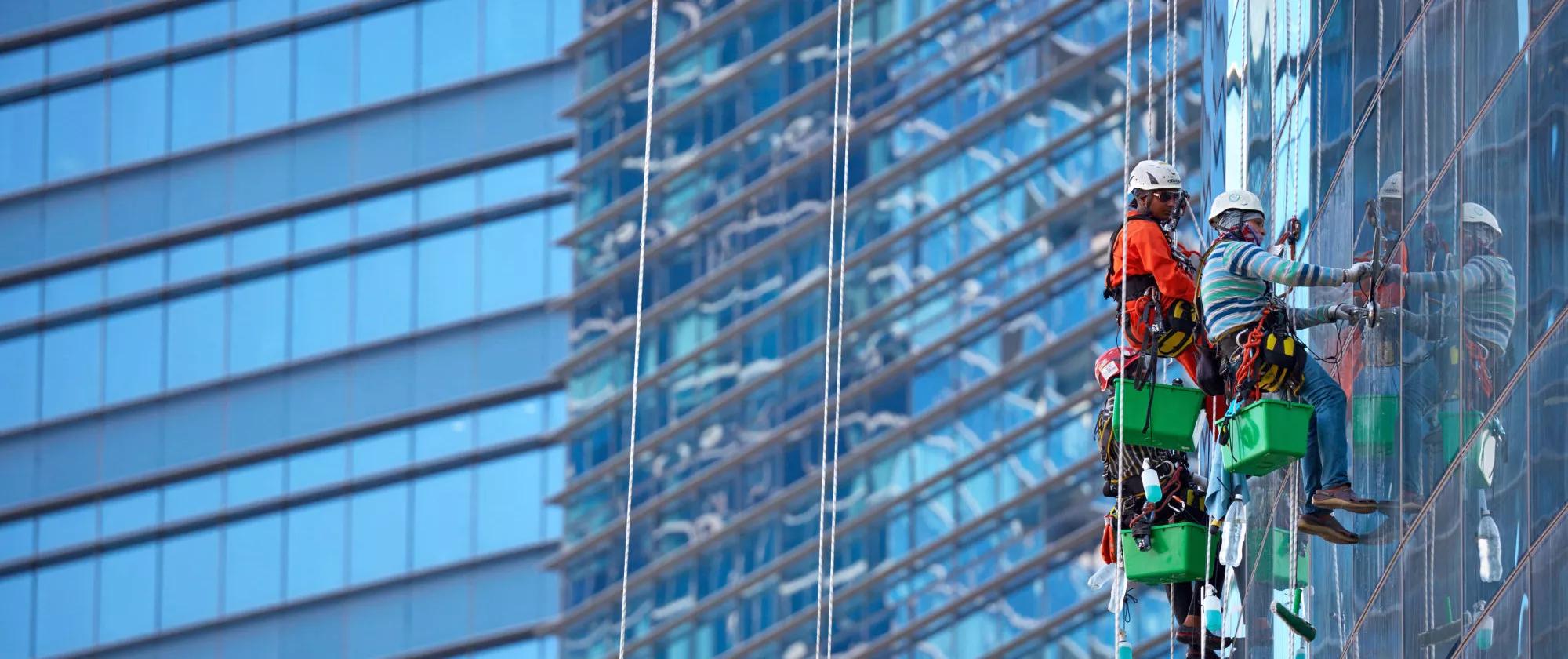 Group of workers cleaning windows at Singapore skyscrape