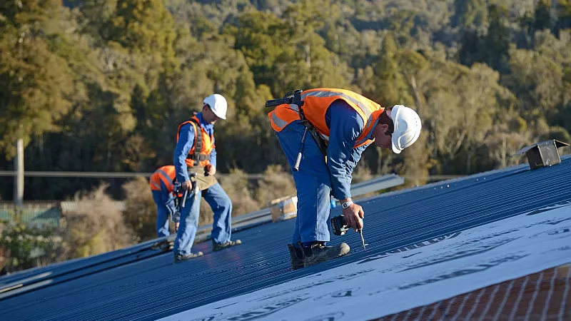 A team of contractors put the roof on a large commercial building near Greymouth, New Zealand