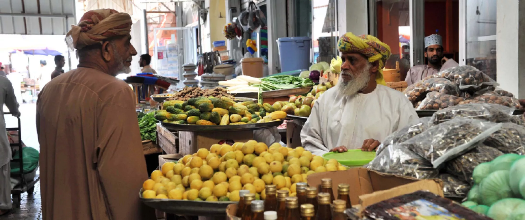 A man in Oman speaks to a lemon seller at a bazaar